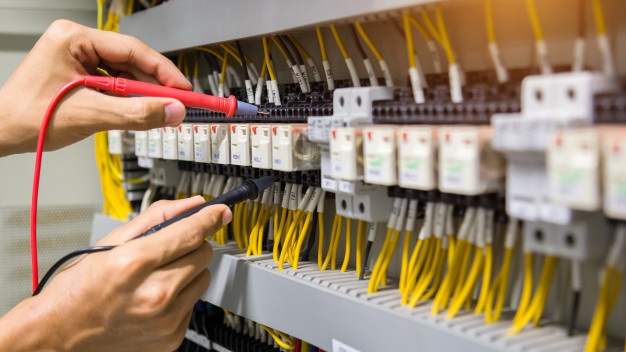 Électricien vérifiant un panneau de commande